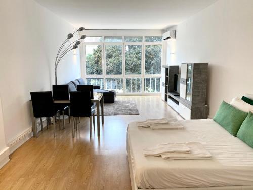 uma sala de estar com uma cama e uma sala de jantar em Estoril Beach Side Casino Garden Apartment Cascais em Estoril