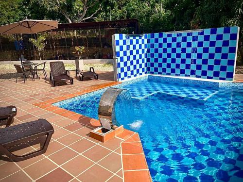 una piscina con azulejos azules y blancos. en Casa Campestre Villa de los Angeles en La Mesa