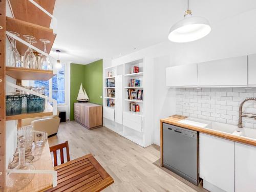 une cuisine avec des placards blancs et une salle à manger dans l'établissement Orléans hypercentre 4 pers appart avec cachet, à Orléans