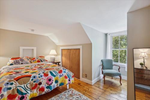 una camera con un letto e una sedia e una finestra di Stowe Farmhouse Apartment a Stowe