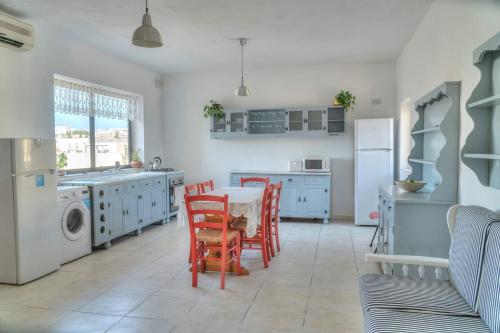 uma cozinha com uma mesa e cadeiras numa cozinha em Double bedroom with ensuite in spacious corner apartment em Birkirkara
