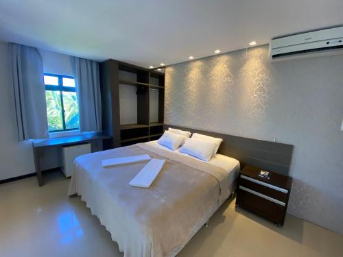 a bedroom with a large bed with two white pillows at Spazio Vital Apartments in Florianópolis