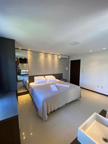 a large bedroom with a large bed and a sink at Spazio Vital Apartments in Florianópolis