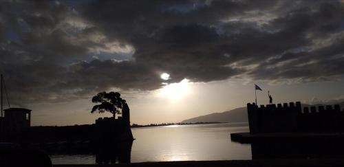 um pôr do sol sobre um corpo de água com um céu nublado em Sea view Villa Dafnes em Lepanto