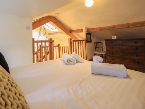 a bedroom with a bed with two towels on it at Jane's Cottage in Ambleside
