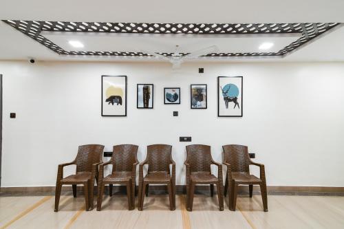 a row of chairs in front of a wall with pictures at Super Townhouse OAK Sayhallo Ecstasy in Bhubaneshwar