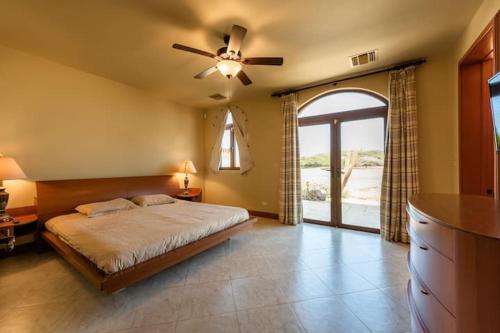 a bedroom with a bed and a ceiling fan at Beverly Hills Aruba in Palm-Eagle Beach