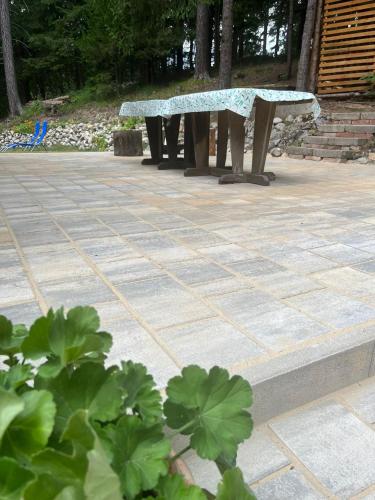 two benches sitting on a patio with plants at Chatka v lese in Ružomberok