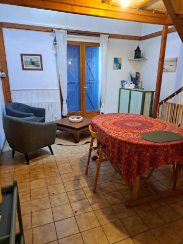 un salon avec une table et une chaise dans l'établissement La Cabane Bleue, à Salles-sur-Mer
