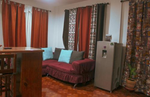 a living room with a red couch and a refrigerator at Departamentos "GARCÍA LÓPEZ" 1 dormitorio a 20min del centro de Oaxaca in Oaxaca City