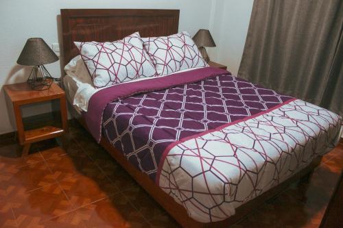 um quarto com uma cama e uma mesa com um candeeiro em Departamentos "GARCÍA LÓPEZ" 1 dormitorio a 20min del centro de Oaxaca em Oaxaca de Juárez