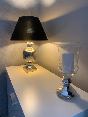 a table with a lamp and a vase on it at Apartament Oliwia in Szczecin