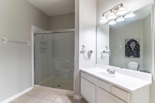 uma casa de banho com um chuveiro, um lavatório e um espelho. em Apartment at Vista Cay Resort em Orlando