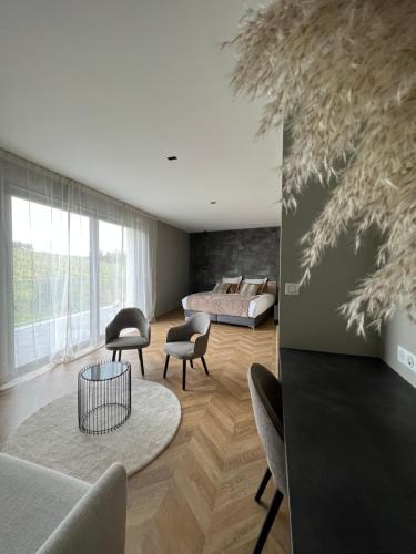 a living room with a bed and a table and chairs at Le Clos des Huy Prés in Trigny