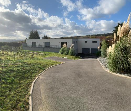 a driveway leading to a white building at Le Clos des Huy Prés in Trigny