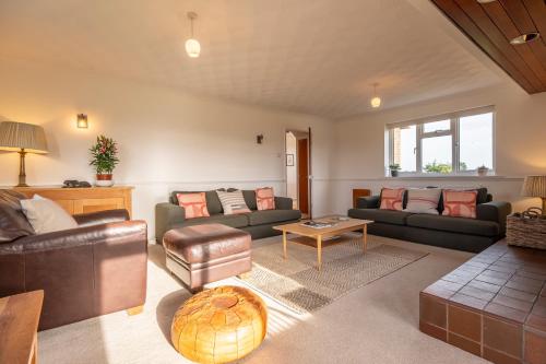 uma sala de estar com dois sofás e uma mesa em Family water sports and cycling getaway - The Lake House em Ipswich