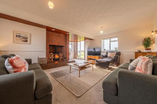 sala de estar con 2 sofás y chimenea en Family water sports and cycling getaway - The Lake House en Ipswich