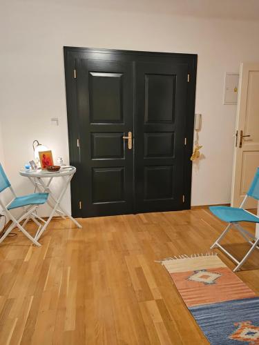 une chambre avec une porte noire, 2 chaises et une table dans l'établissement Laxmi Happy Home in historical Prague, à Prague