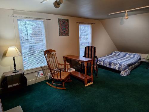 um quarto com uma secretária, uma cama, uma mesa e cadeiras em Terrapin Hostel em Kingfield
