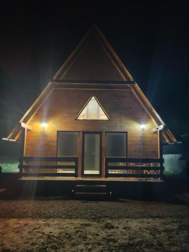 ein Holzhaus bei Nacht mit eingeschaltetem Licht in der Unterkunft ALI HOUSE in Poiana Fagului