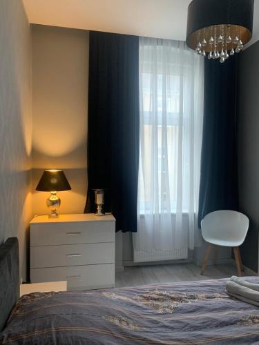 a bedroom with a bed and a dresser and a window at Apartament Oliwia in Szczecin