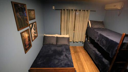 a small bedroom with a bed and a window at Chalé Casa de Pedra, Vivenda Serra Velha, Chalés de Montanha in Timbe do Sul