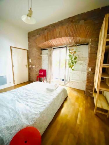 une chambre avec un grand lit et une grande fenêtre dans l'établissement Mon bout de Garonne - Appartement, à Toulouse