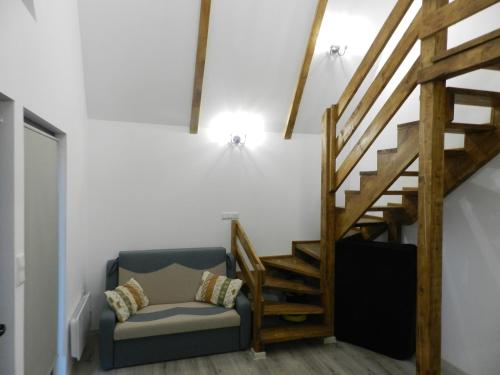 a living room with a staircase and a chair at ALI HOUSE in Poiana Fagului