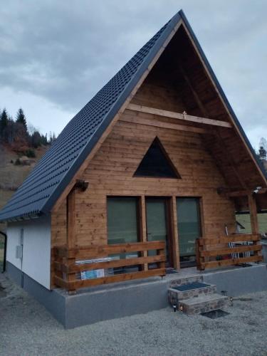 eine Blockhütte mit Mansarddach in der Unterkunft ALI HOUSE in Poiana Fagului
