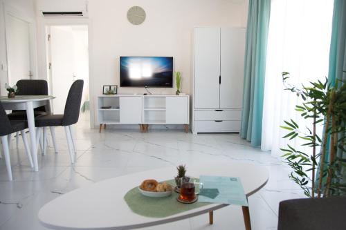 a living room with a tv and a table at Art Life apartments (Olive) in Alanya