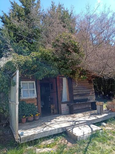 a small cabin with a porch and a bench at BAJO EL ÑIRE in San Carlos de Bariloche