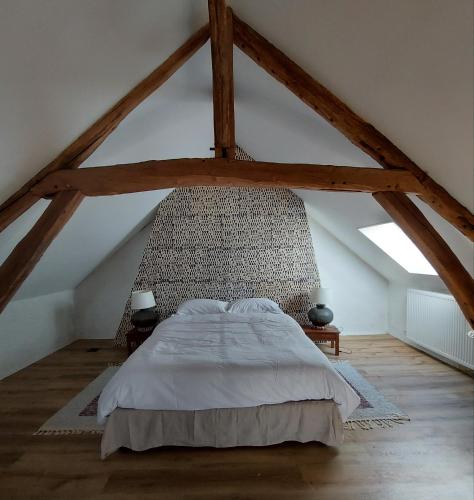 ein Schlafzimmer mit einem großen Bett im Dachgeschoss in der Unterkunft Maison Figuier - Cottage anglais in Argent-sur-Sauldre