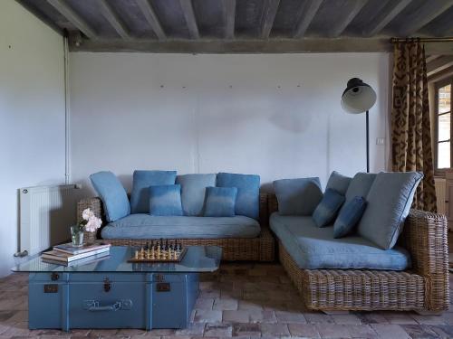 ein Wohnzimmer mit einem blauen Sofa und einem Tisch in der Unterkunft Maison Figuier - Cottage anglais in Argent-sur-Sauldre
