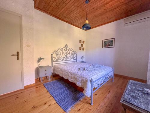 a bedroom with a bed and a wooden ceiling at Casa Calma Villa Greece in Diakopto