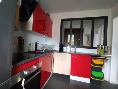 una cocina con armarios rojos y blancos y fregadero en appartement T2 - 4 personnes, en Pau