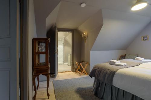 a bedroom with a bed and a stairway leading to a bathroom at Mellby Atelier på Österlen in Kivik