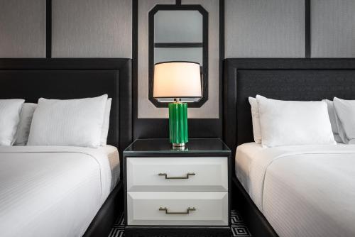 a bedroom with two beds and a lamp on a night stand at Caesars Palace Hotel & Casino in Las Vegas