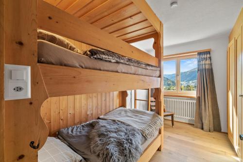 a bedroom with two bunk beds and a window at A&Y Chalet zum goldenen Hirsch in Davos