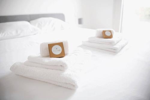 uma cama com toalhas e um despertador em Beautiful Stylish 2BR Apartment in Kirchberg no Luxemburgo