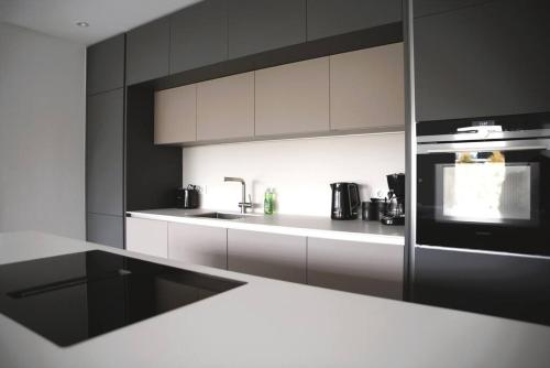a kitchen with white cabinets and a stove top oven at Beautiful Stylish 2BR Apartment in Kirchberg in Luxembourg