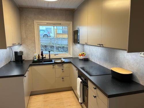 a kitchen with black counter tops and a window at Arctic 3 room apartment - Aurora View - Free Parking in Tromsø