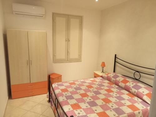 a bedroom with a bed and a cabinet in it at Appartamento Giglio in Trapani