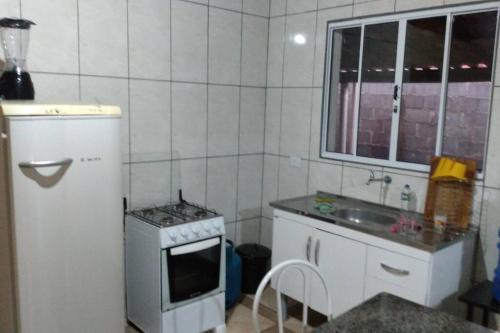 een kleine keuken met een fornuis en een wastafel bij Chacara São Pedro in Socorro