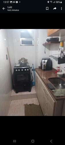 uma pequena cozinha com um fogão e um lavatório em Doca no Rio de Janeiro