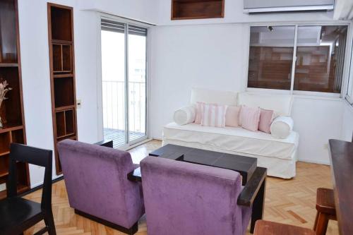 sala de estar con sofá y 2 sillas moradas en Libertador 2785 by depptö in 