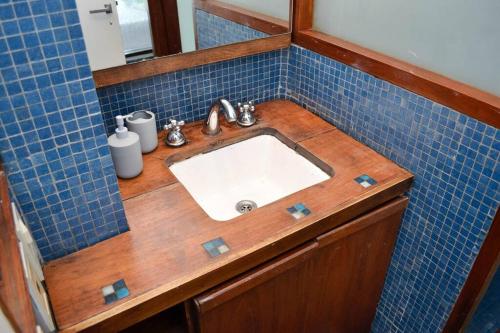 baño con lavabo y pared de azulejos azules en Libertador 2785 by depptö in 