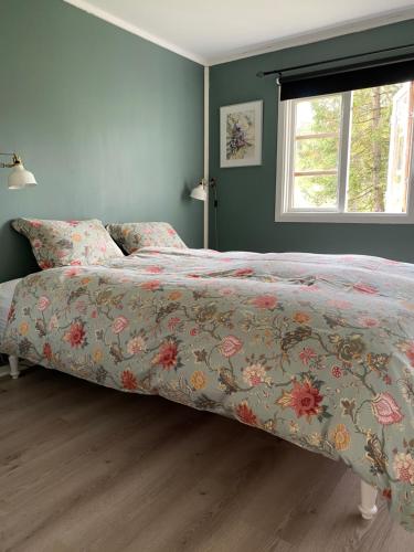a bedroom with a bed with a floral bedspread at Stuga Bergvik in Gällö