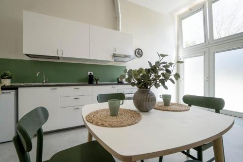 a white kitchen with a table with a vase on it at casadelfalegname ABETE in San Giovanni in Bosco