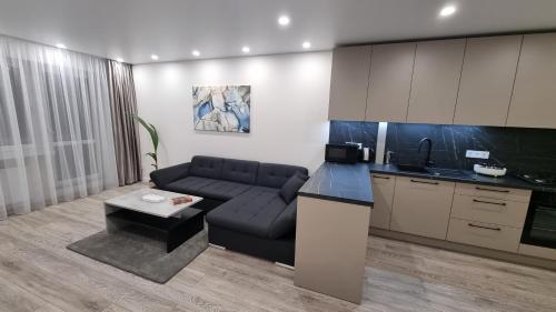 a living room with a couch and a kitchen at New apartment in the city in Šiauliai