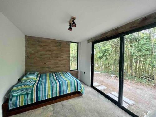 um quarto com uma cama e uma grande janela em Casa campestre Lago Calima em Calima
